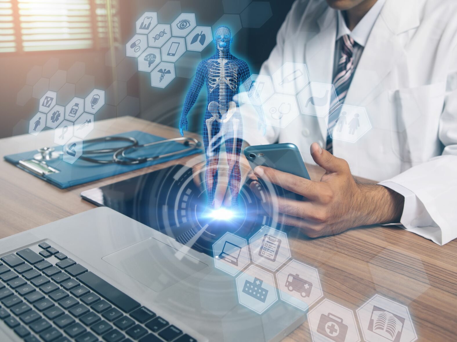 Arzt sitzt am Schreibtisch vor dem Laptop. In der Hand hält er ein Smartphone. Über dem Foto sind virtuelle eHealth-Tools sowie ein digitalisierter menschlicher Körper abgebildet.